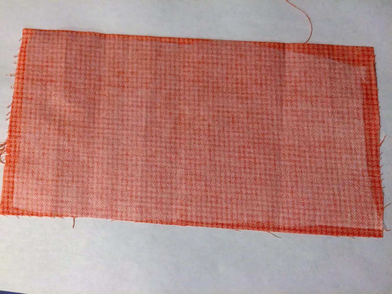 Interfacing on back of orange fabric rectangle.