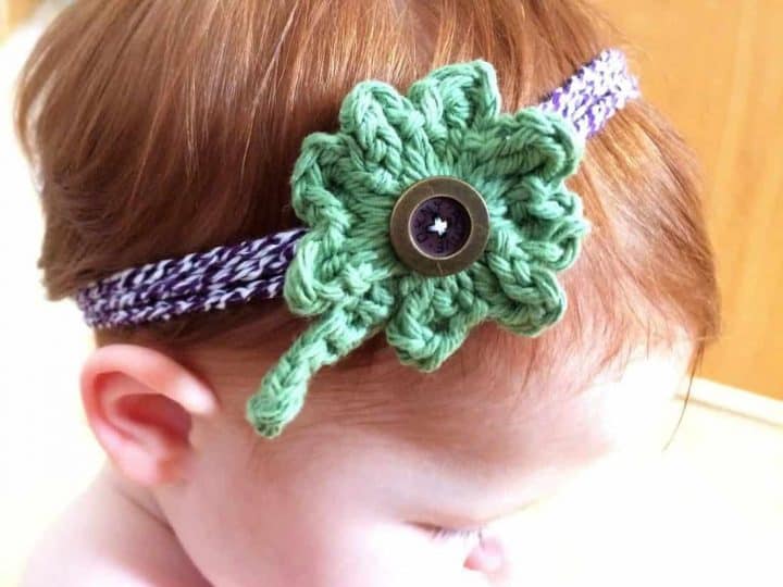 Girl wearing a crochet four leaf clover headband.