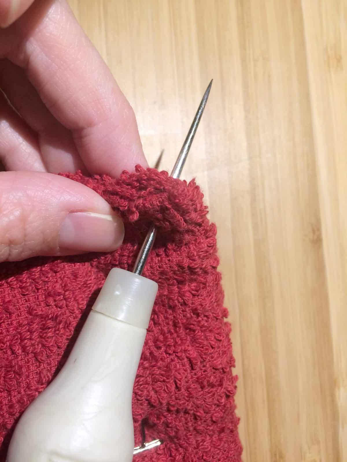 Use awl to punch holes to add crochet towel topper.