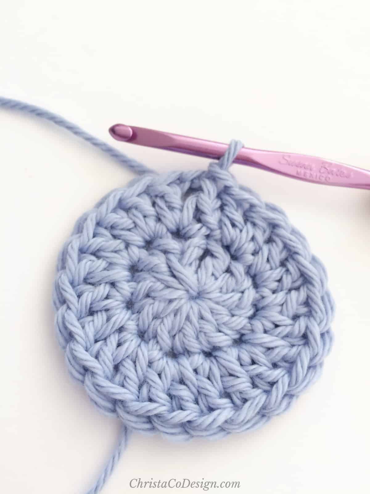 Magic circle crochet circle in blue yarn.
