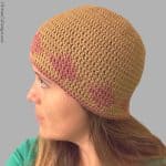 Woman with head turned in crochet chemo cap.
