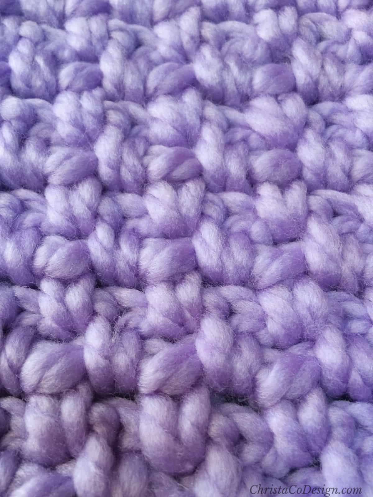 Crochet moss stitch in purple yarn.