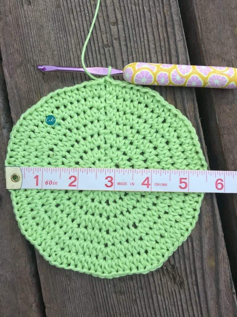Crown of hat in green with tape measure.