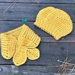 Finished mustard colored beret and scarflette laid flat on boards.