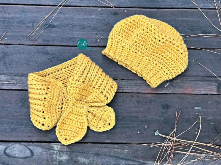 Finished mustard colored beret and scarflette laid flat on boards.
