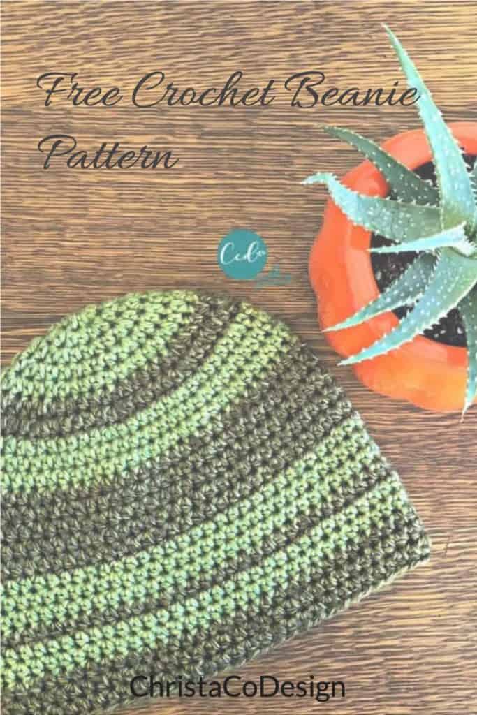 Green striped beanie flat on table.