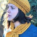 Woman in gold beret and scarflette.