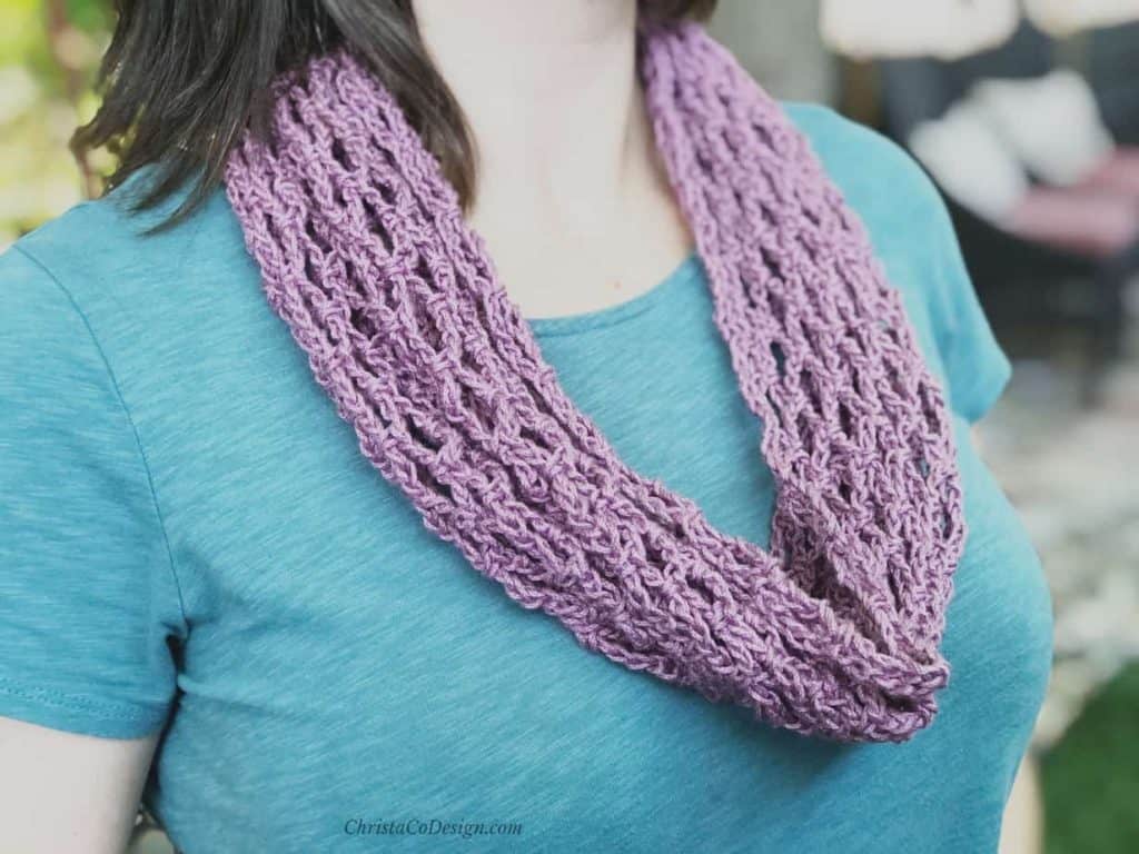 Lilac crochet cotton cowl draped on woman in teal.