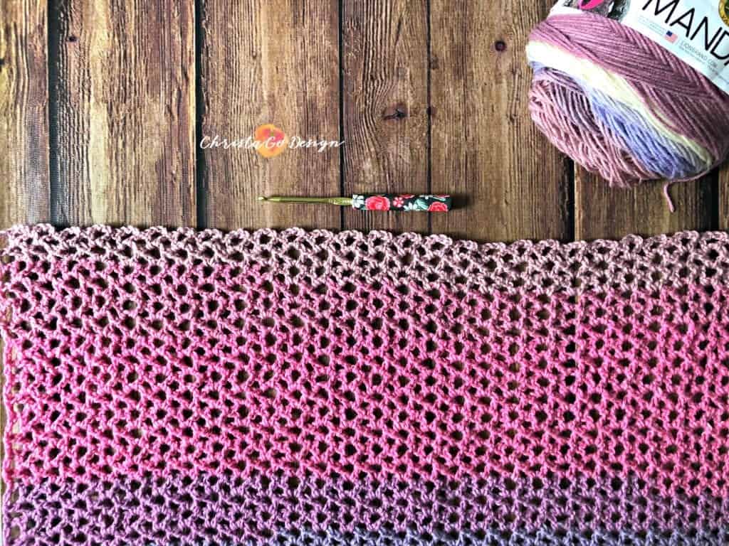 Self striping purple to pink crochet lace poncho laid flat.