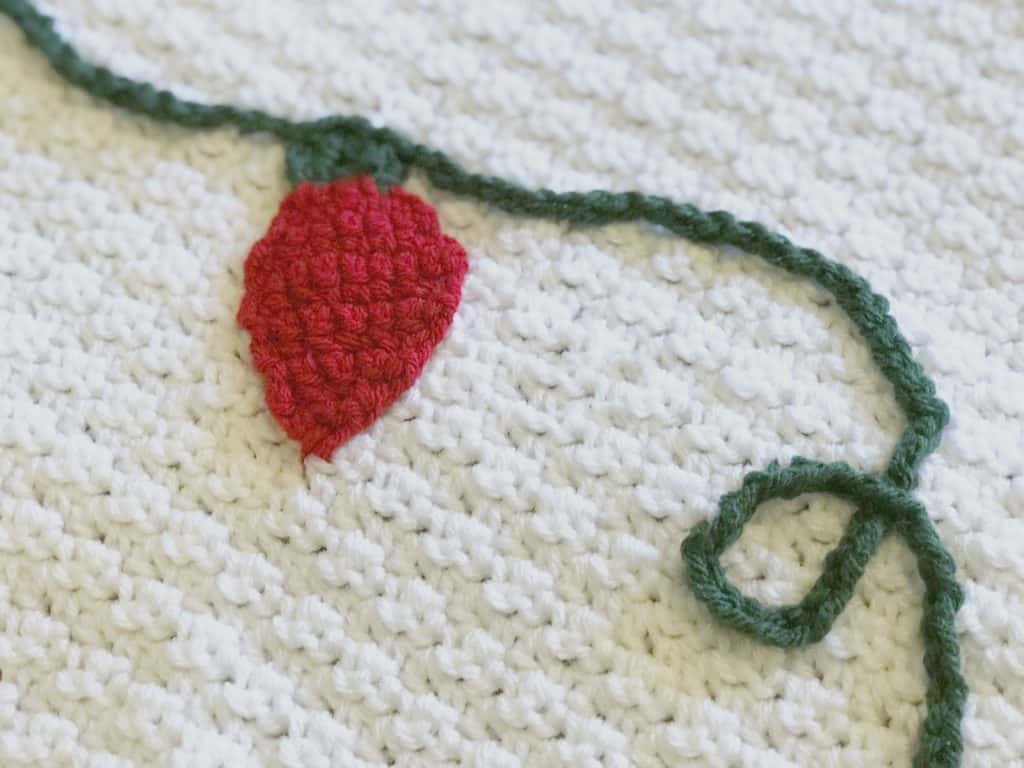 Crochet Christmas light in red on white crochet blanket free crochet pattern.
