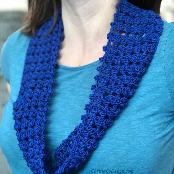 Dark blue crochet circle scarf over lighter blue shirt.