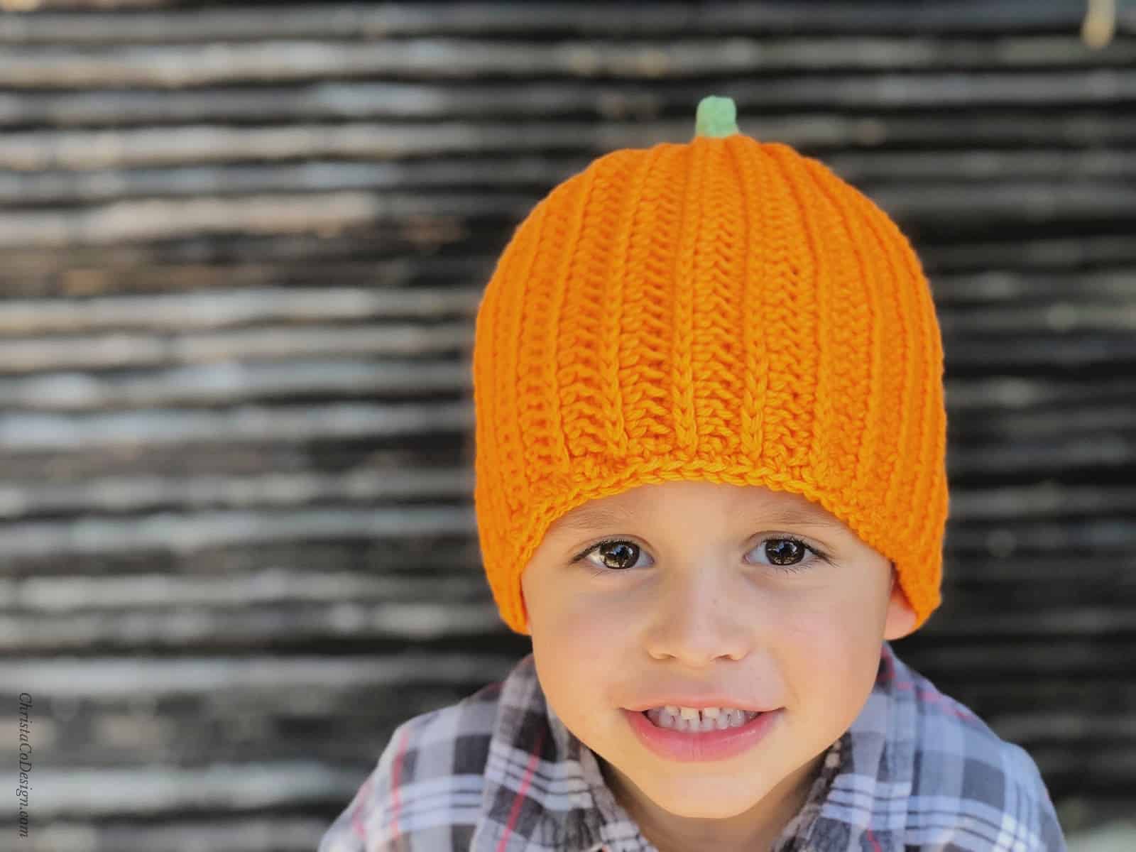 Crochet pumpkin hat pattern in orange on preschooler.