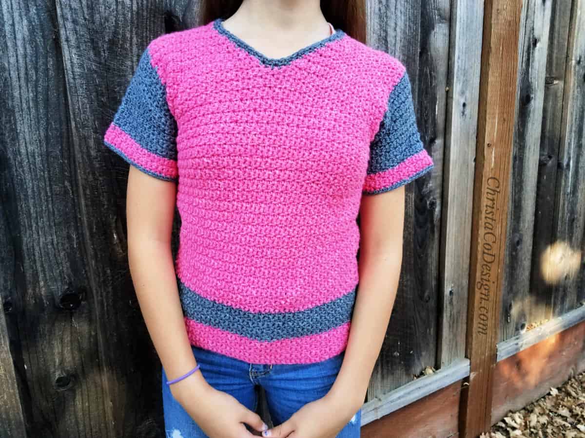 Teen size crochet sweater in pink and grey on girl.
