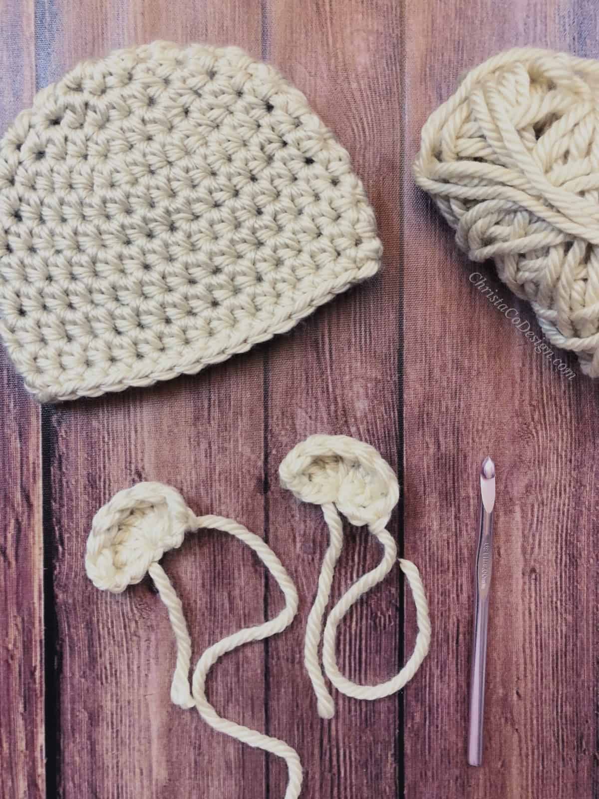 Two crochet bear ears ready to sew on crochet hat in chunky yarn.
