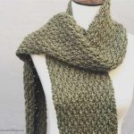 Green textured crochet scarf on mannequin.