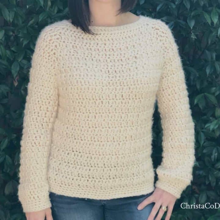 Woman in cream fuzzy crochet sweater.
