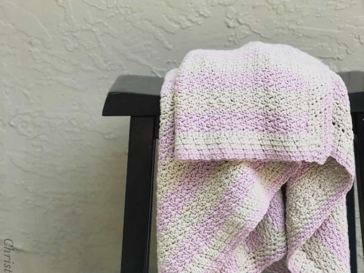 Pink and grey blanket draped on stool.