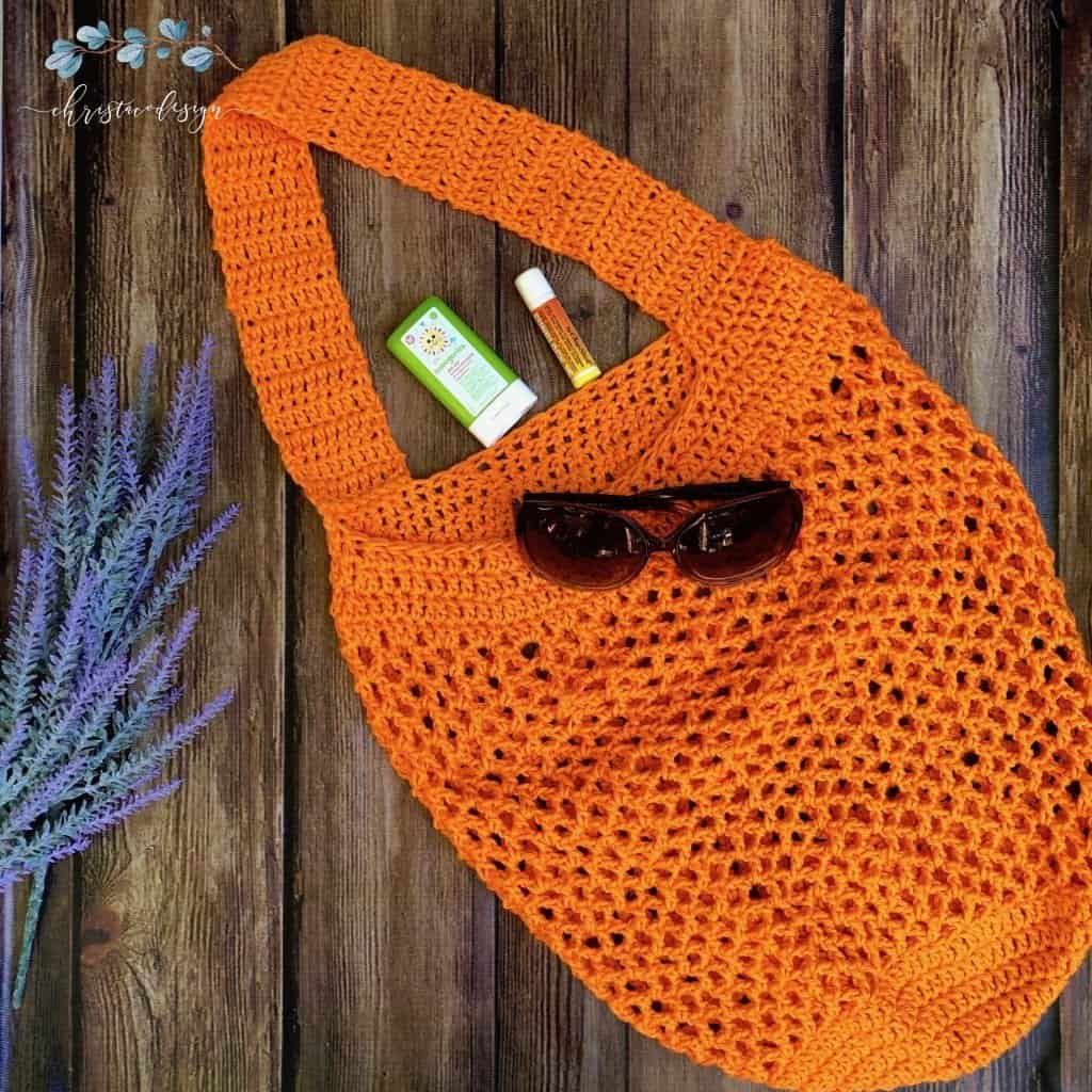 picture of orange beach bag with sunglasses flat