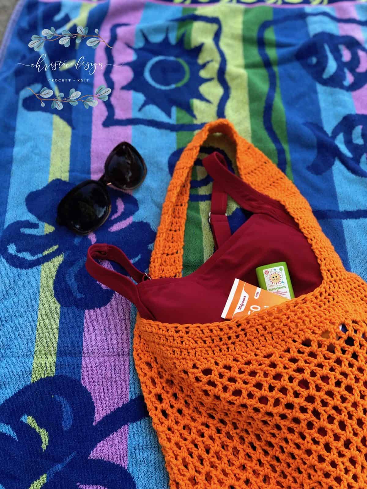 picture of orange crochet market tote bag on beach towel