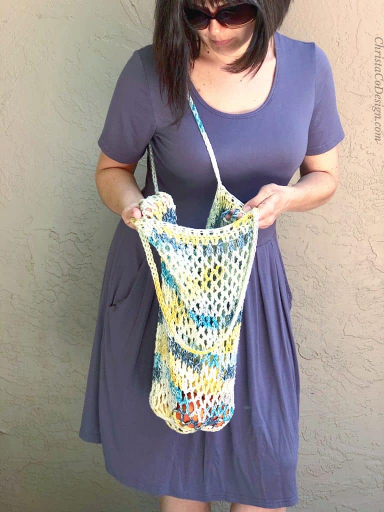Woman looking into crochet tote bag free pattern.