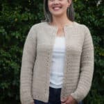 Woman in beige crochet cardigan with eyelet detail.