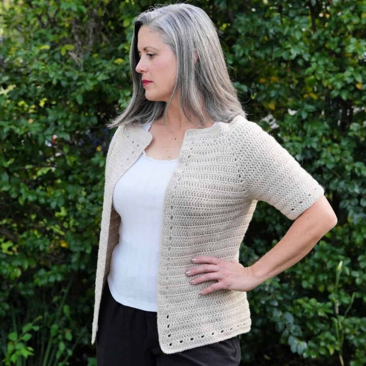 Woman turned to side in short sleeve cardigan.