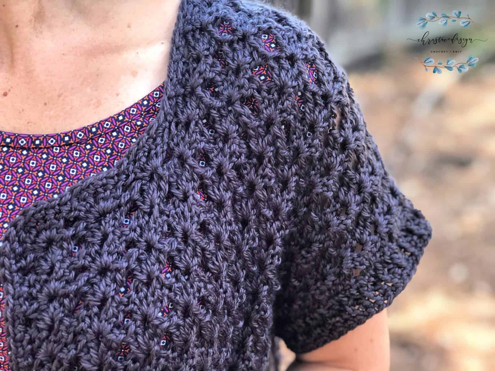Close up of short sleeve on woman's crochet cardigan,
