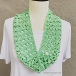Light green crochet cowl on mannequin in white dress.