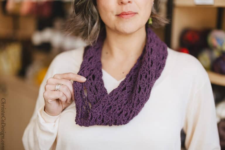 Close up of purple lace cowl on woman's neck.