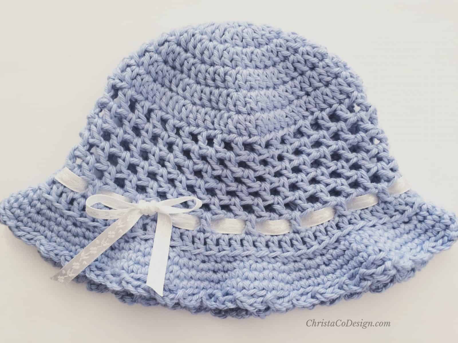 Crochet sun hat flat in light blue with ribbon.