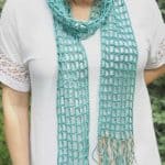 Teal mesh crochet skinny scarf on woman in white shirt.