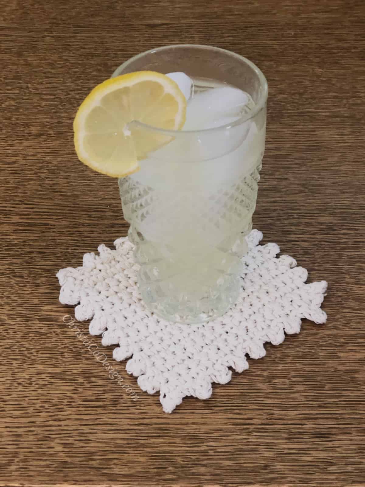 picture of glass of lemonade with lemon wheel on crochet coaster