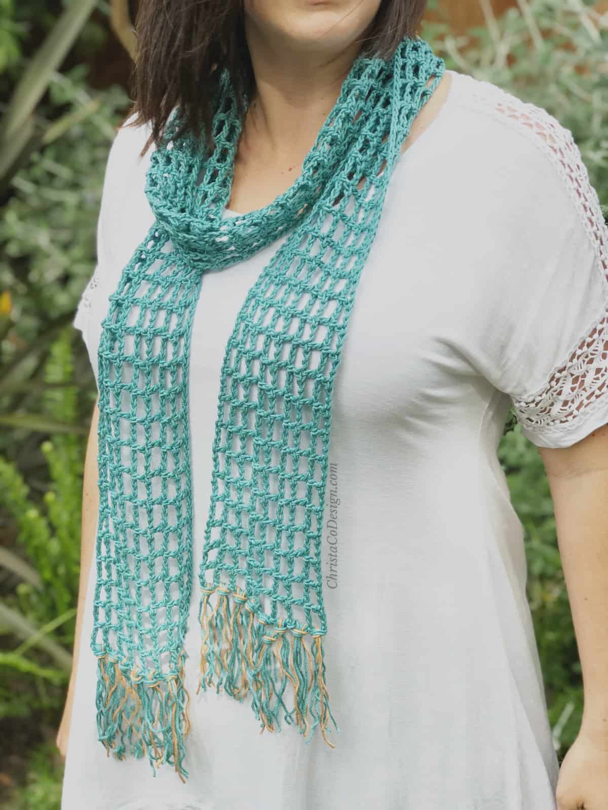Woman wearing teal lace skinny summer scarf.