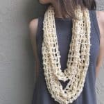 Woman wearing cream lace crochet infinity cowl.