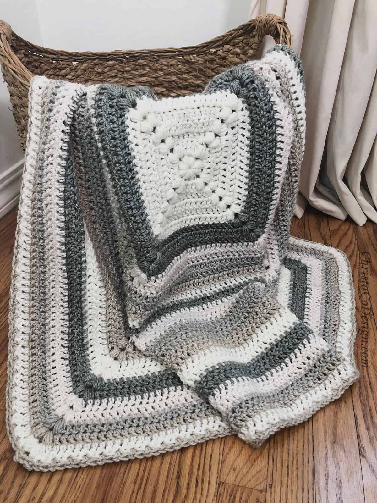 picture of grey and white crochet puff stitch blanket in basket