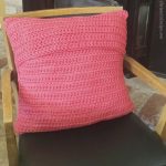 picture of red crochet pillow with envelop closure on dining room chair