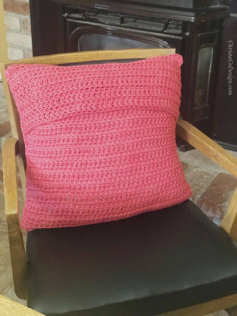 picture of red crochet pillow with envelop closure on dining room chair
