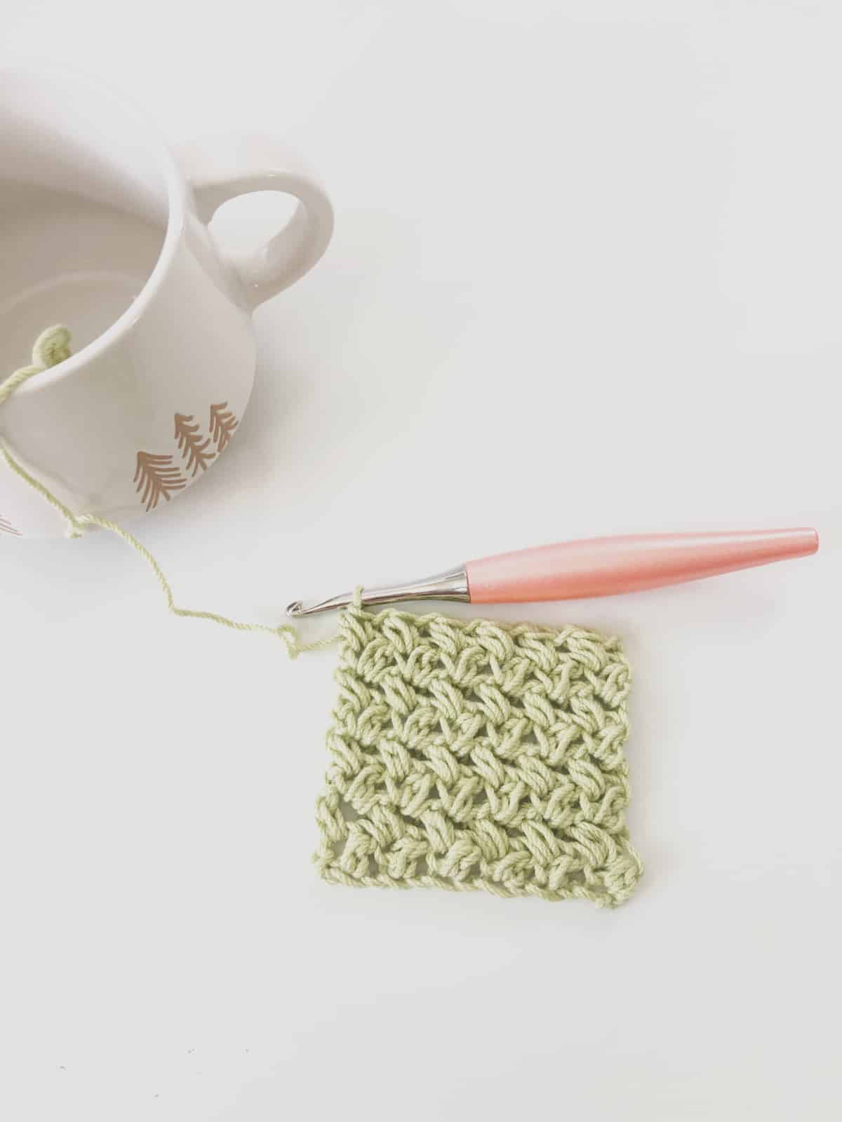 Lime green crochet mini bean stitch crochet swatch on peach hook.