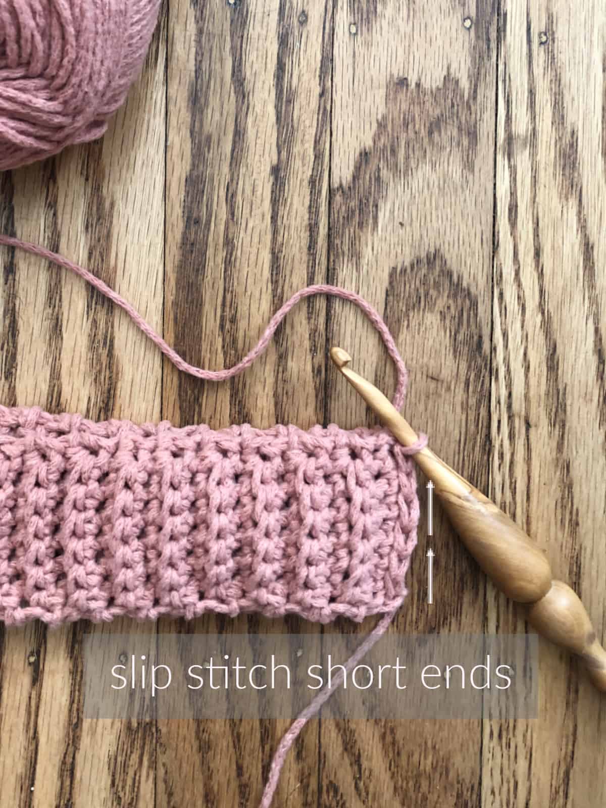 Crochet ribbing for bottom up hat in pink yarn with wood hook and words that say to slip stitch short ends.