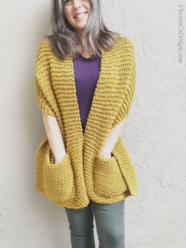 Woman wrapped in honey colored knit pocket shawl pattern.