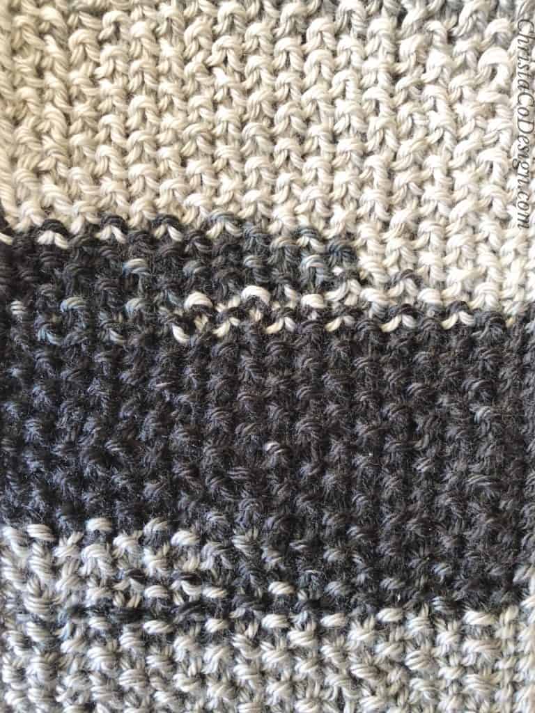 Grey and black ombre fabric in seed stitch.