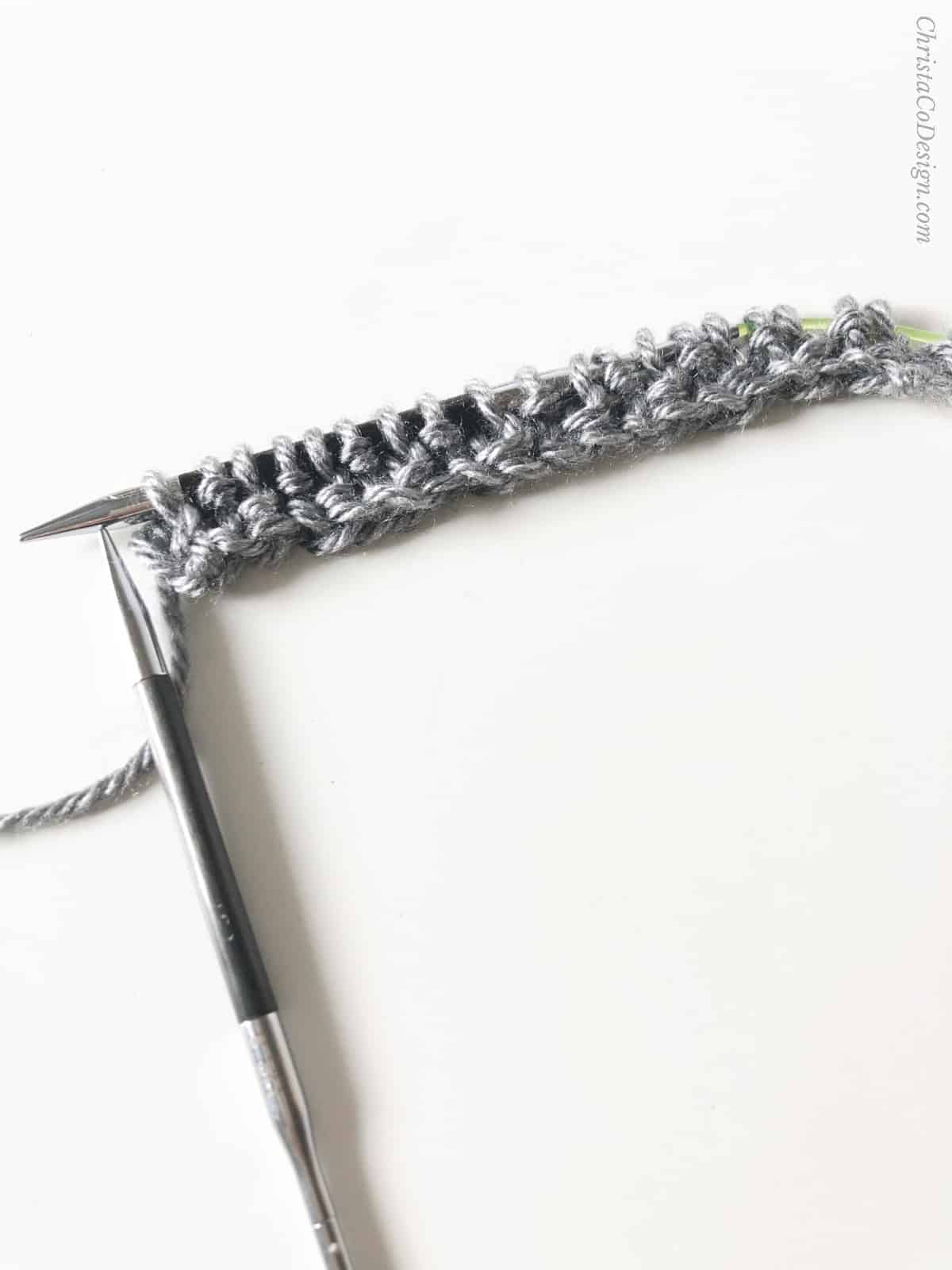 Seed stitch rows on knitting needle.