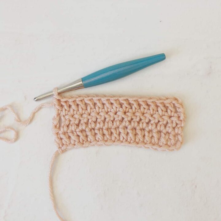 Row 3 of double crochets in pink yarn with turquoise hook.