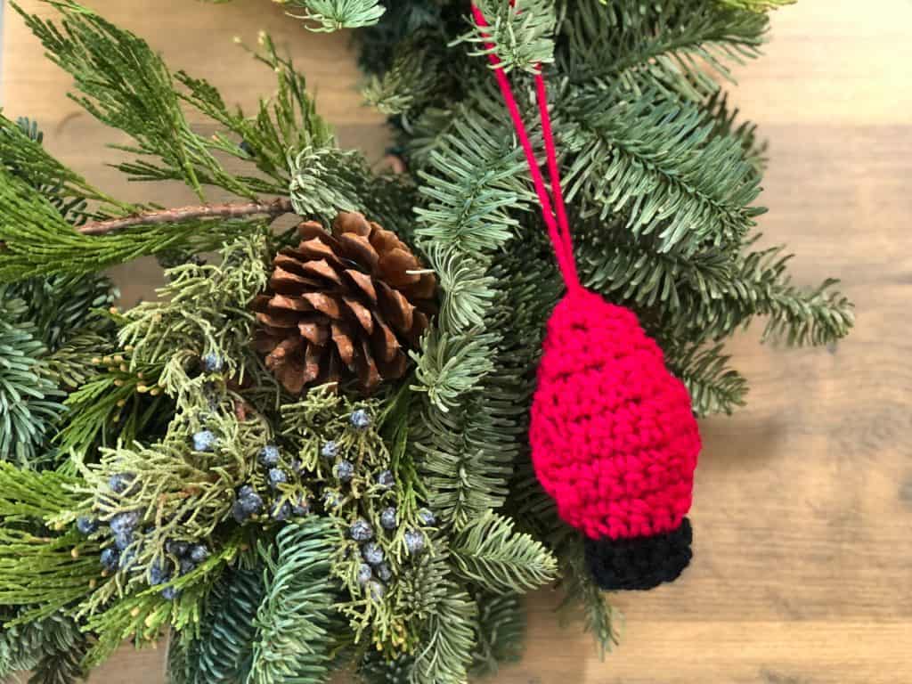 picture of crochet christmas lightbulb in red hanging on wreath