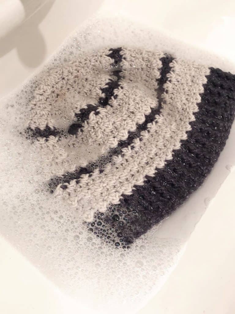 Crochet hat soaking in soapy water for blocking