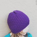 A girl in a purple knit hat.