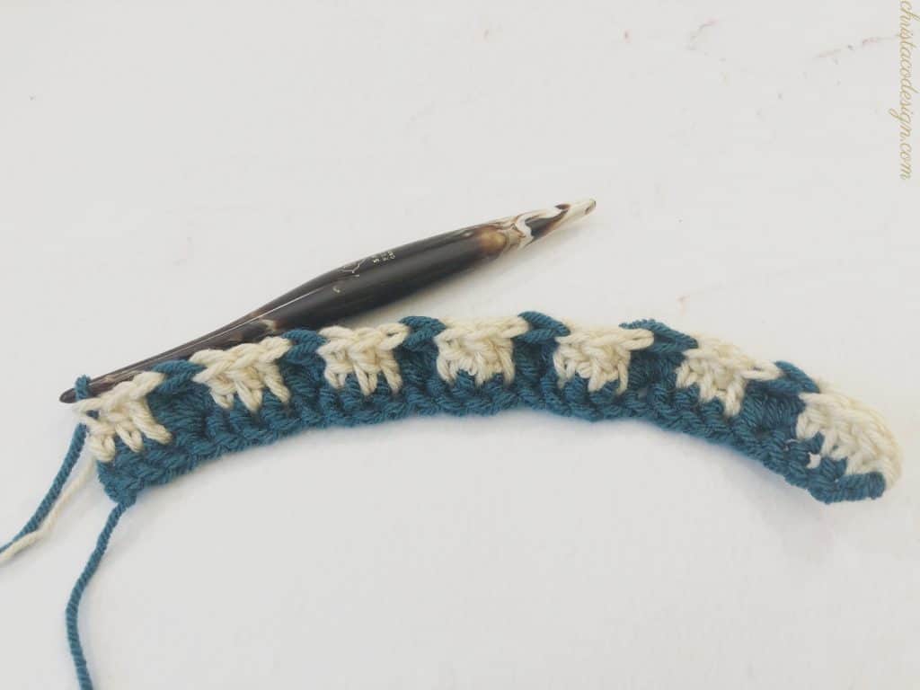 Blue and beige color changes in a crochet row.
