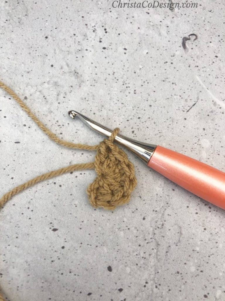 Crochet half circle in brown on peach hook.