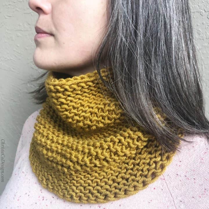 Woman with honey yellow cowl knit in garter on neck.