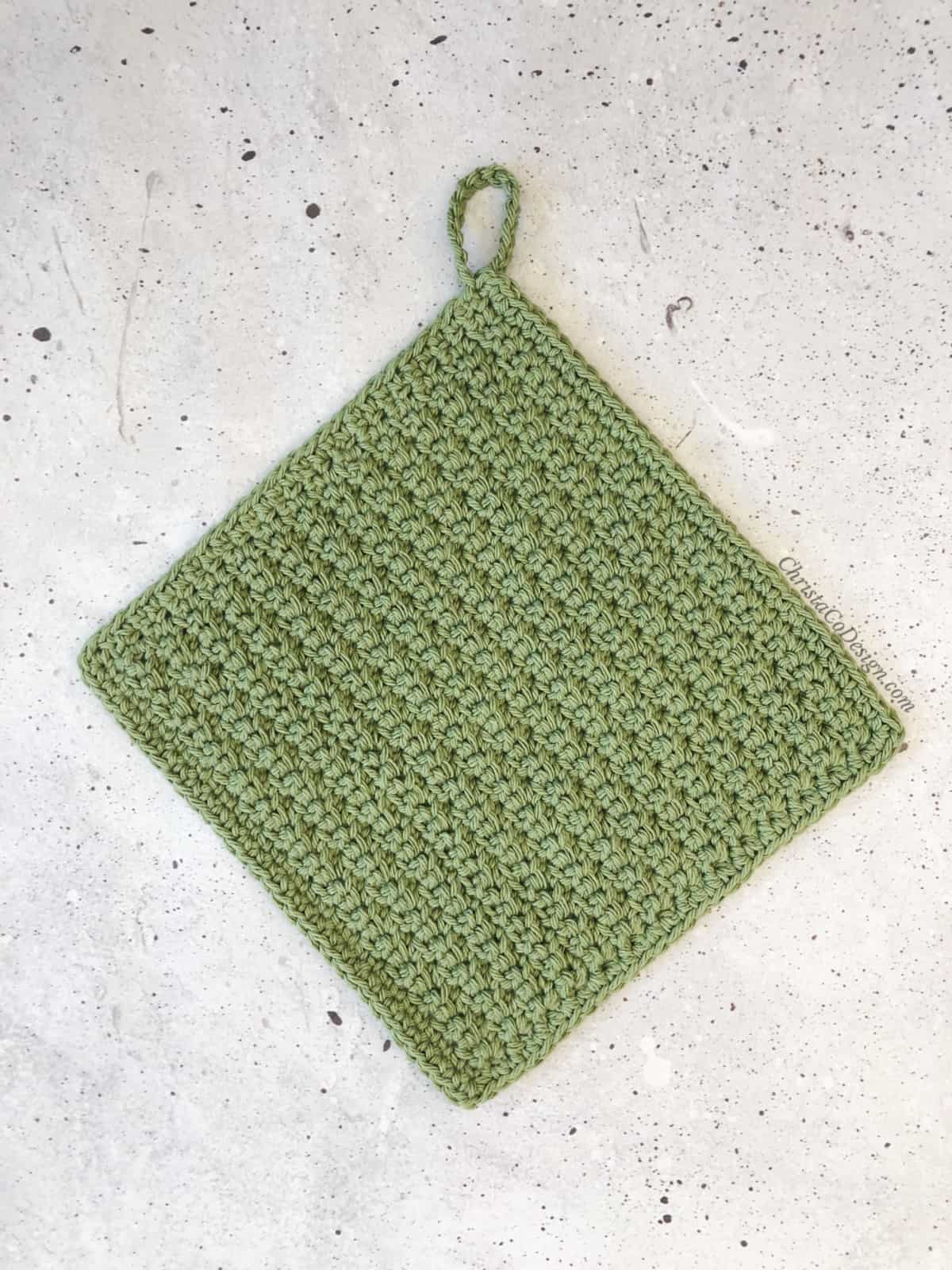Crochet dishcloth in green with loop.